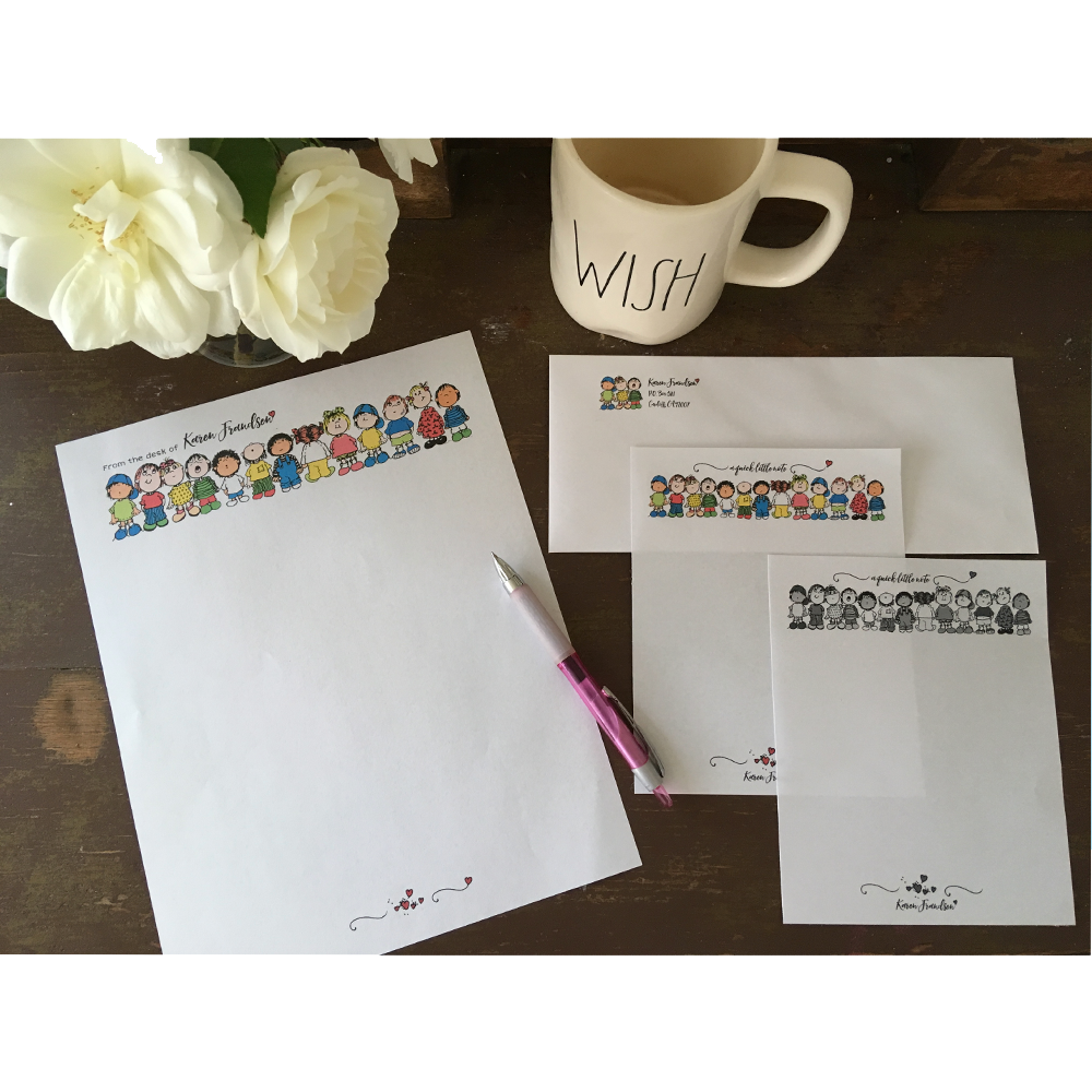 Samples of stationery and notepads make with colored clipart on a table with roses, pink pen and tea cup.